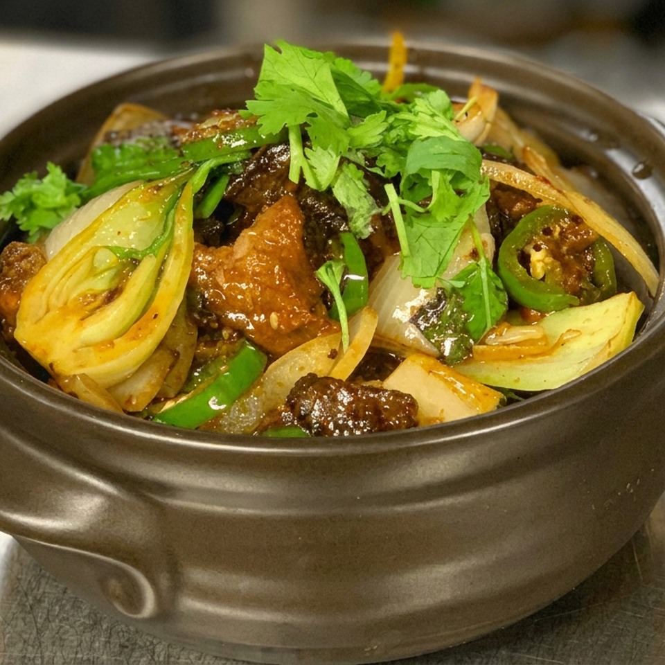 Glazed stir-fried vegetables and meat topped with fresh cilantro in a dark ceramic bowl.